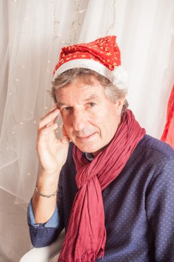 Stüdyoda oturan olgun adam.