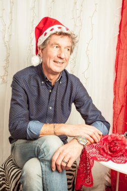 Stüdyoda oturan olgun adam.