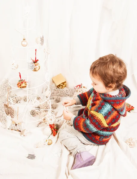 Noel süslemeleri ile oynarken güzel küçük kız. — Stok fotoğraf