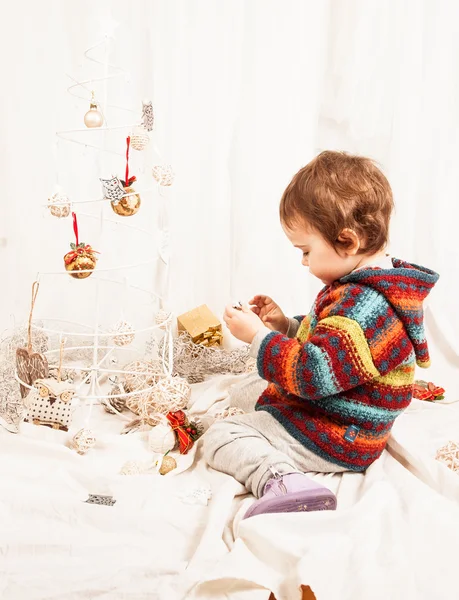 Noel süslemeleri ile oynarken güzel küçük kız. — Stok fotoğraf