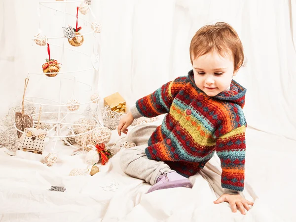 Noel süslemeleri ile oynarken güzel küçük kız. — Stok fotoğraf