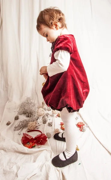 Krásná holčička hraje s vánoční ozdoby. — Stock fotografie
