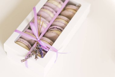 Beyaz masadaki renkli kurabiyeler. Hediye kutusundaki bir kurabiyenin görüntüsü, seçici odak noktası.