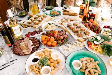 Lezzetli yiyecek ve atıştırmalıklarla dolu yuvarlak masa ziyafeti, güzel bir ortam, yemek servisi, temiz havada tatil.