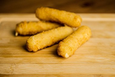 Ahşap bir arka planda mozzarella ile peynir çubukları