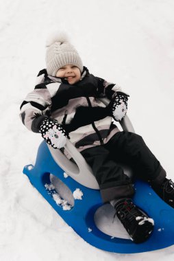 Kar kızağındaki tatlı çocuk, aktif yaşam tarzı, kış, aile.