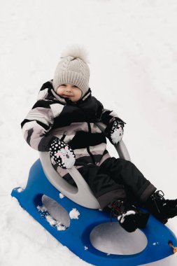 Kar kızağındaki tatlı çocuk, aktif yaşam tarzı, kış, aile.