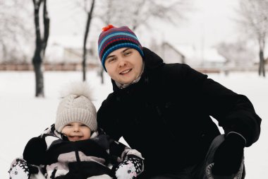 Babam kızakla kızakla gezen tatlı bir çocuk. Aktif yaşam tarzı, kış, aile.