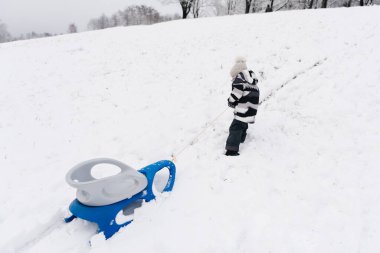 Kar kızağındaki tatlı çocuk, aktif yaşam tarzı, kış, aile.
