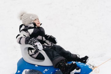 Kar kızağındaki tatlı çocuk, aktif yaşam tarzı, kış, aile.