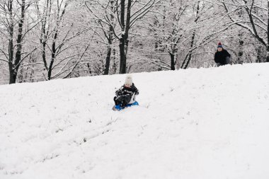 Babam kızakla kızakla gezen tatlı bir çocuk. Aktif yaşam tarzı, kış, aile.