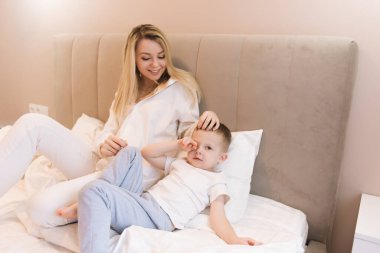 Güzel, genç bir anne, bebeğiyle gülüyor, gülümsüyor, mutlu bir aile.