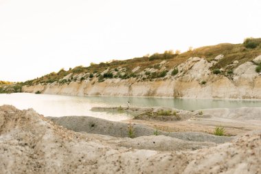 Birbirlerine aşık güzel bir çift, bir erkek ve bir kadın, gün batımında mavi bir göl ve kum kenarında öpüşürler. Sahilde deniz tatili, gün batımı, sabah, balayı, tropik hava, okyanus, kız, ilişki..
