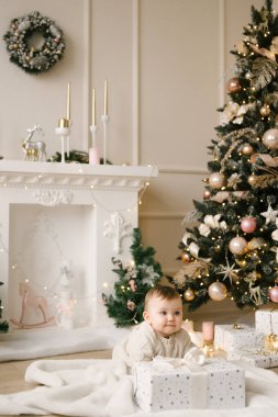 Noel ağacının altında küçük tatlı bir kız bebek. Mutlu tatiller, mutlu yıllar. Noel Zamanı