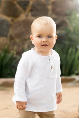 Güneşli bir günde dışarıda oynayan sevimli bir çocuk.