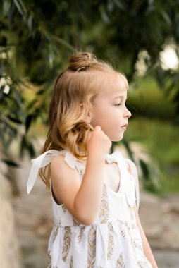 Güneşli bir günde dışarıda oynayan sevimli küçük kız.