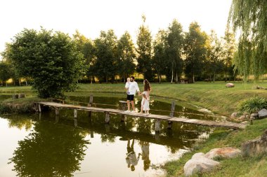 Mutlu erkek ve kadın güneşli bir günde dışarıda çocuklarla oynuyorlar.