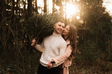 Genç ve güzel mutlu aşıklar, kışın güneşin altındaki bir çam ormanında yaşayan bir Noel ağacıyla aşk hikayesi.