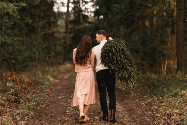 Genç ve güzel mutlu aşıklar, kışın güneşin altındaki bir çam ormanında yaşayan bir Noel ağacıyla aşk hikayesi.