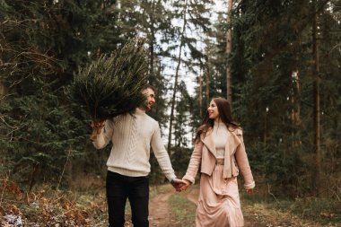 Genç ve güzel mutlu aşıklar, kışın güneşin altındaki bir çam ormanında yaşayan bir Noel ağacıyla aşk hikayesi.