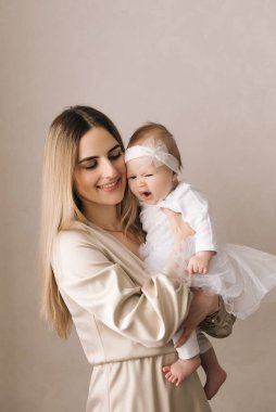 Sevgi dolu anne, yeni doğmuş bebeğini evde taşıyor. Uyuyan bebeği elinde tutan mutlu annenin parlak portresi. Anne, 4 aylık oğluna sarılıyor..