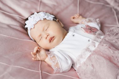 6 aylık şirin bir bebeğin portresi, beşikteki bebek elbiseli küçük bir kız.