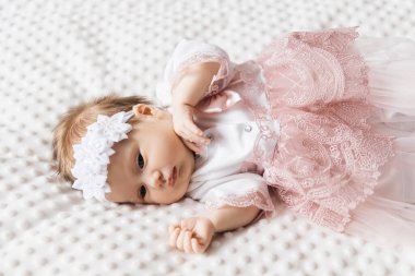 6 aylık şirin bir bebeğin portresi, beşikteki bebek elbiseli küçük bir kız.