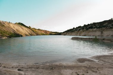 Yakından beyaz kil kaplı kıyı, gölette turkuaz mavisi su, berrak mavi suyu olan sığ göl, parlak yüzey.