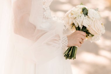 Pastel renkte düğün buketi güllerin, mutluluğun, şakayıkların, karanfillerin ve okaliptüslerin ellerinde..