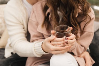 Dışarıda çadır kurmuş, dağların tepesinde kamp kurmuş sıcak çay içen mutlu bir çiftin görüntüsü..