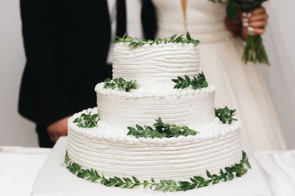 奢华的婚礼层次分明 白色蛋糕装饰着花朵 夜晚在灯光的映衬下拍照 — 图库照片