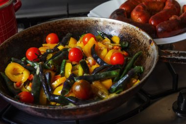 Tavada sebze güveci ve ev yapımı sosis.