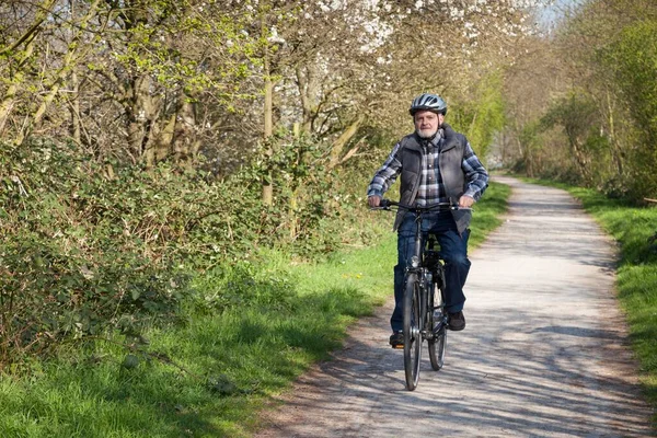 Senior with bicycle helmet riding a bike, North Rhine-Westphalia, Germany, Europe