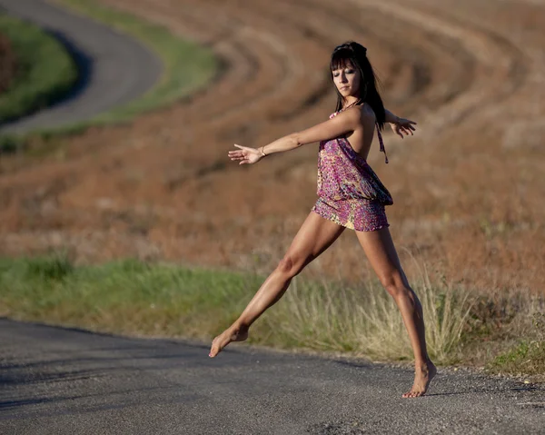 Жінка витончено перетинає сільську дорогу — стокове фото