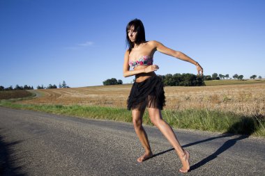 Dansçı bir ülke yolda bir renkli mayo üst giyiyor.