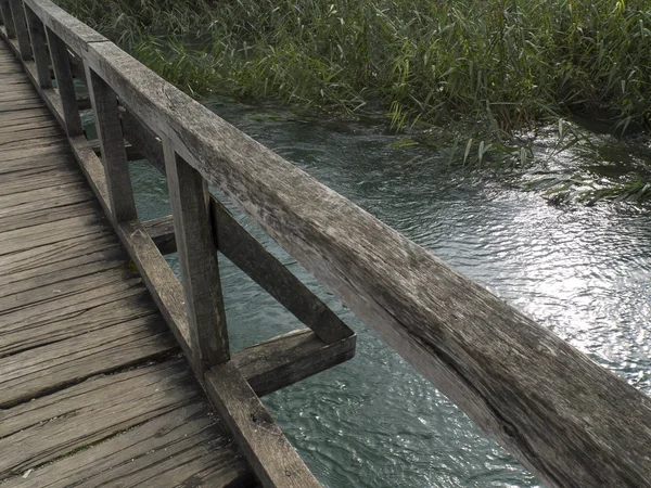 Wooden bridge on a small river. — Stock Photo, Image