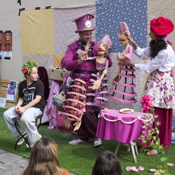 Straßenspieler spielen mit großen rosafarbenen Marionetten. — Stockfoto