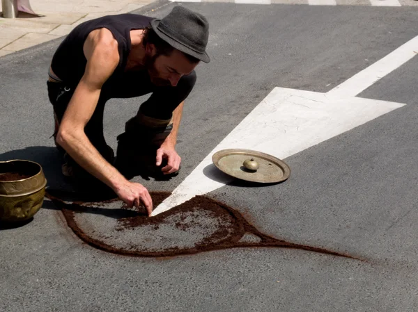 Street performer draw a symbol on the asphalt. — Stock Photo, Image