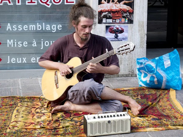 Músico descalzo y peludo tocando la guitarra en la calle . — Foto de Stock