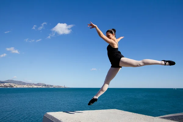 Akdeniz deniz kenarında bir blok taş üzerinde atlama dansçı. — Stok fotoğraf