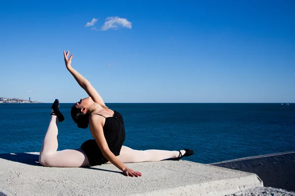 Supple woman exercises in front of the Mediterranean sea. — Stock Photo, Image