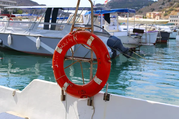Bóia salva-vidas vermelha ligada ao corrimão do navio — Fotografia de Stock