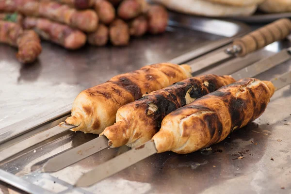 Meat on wooden skewer covered with dough — Stock Photo, Image