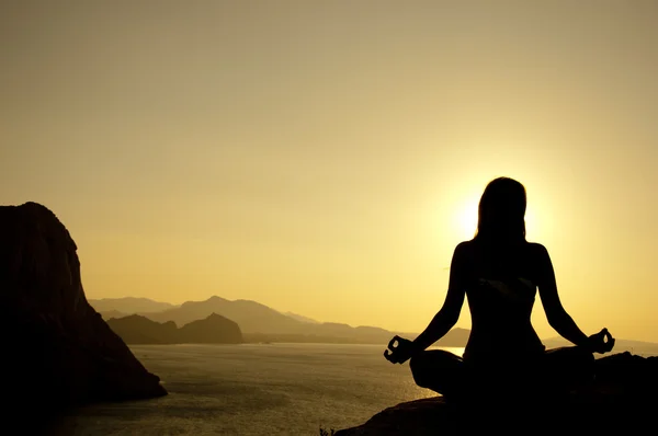 Silueta de posición de loto de yoga en la playa al amanecer —  Fotos de Stock