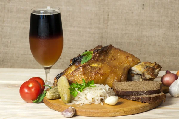 Pierna de cerdo asada servida con chucrut y cerveza en rodajas —  Fotos de Stock