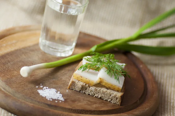 Sandwich with salted lard on rye bread and vodka and garlic — Stock Photo, Image