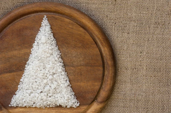 Árbol de Navidad sobre tabla de cortar de madera y fondo de saco — Foto de Stock