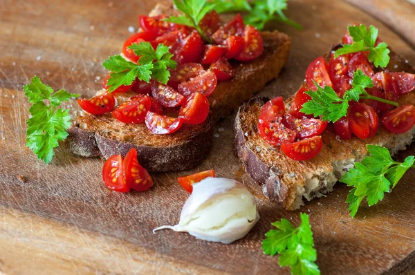 Italian bruschetta with cherry tomatoes on whole grain bread — Stock Photo, Image