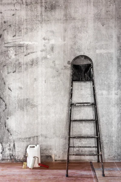 Old dirty concrete wall in repairing room with stepladder and to — Stock Photo, Image