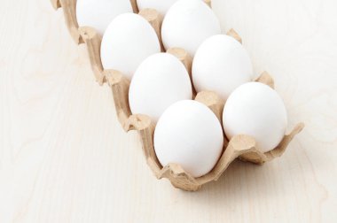 Masadaki kareli pakette beyaz tavuk yumurtası.